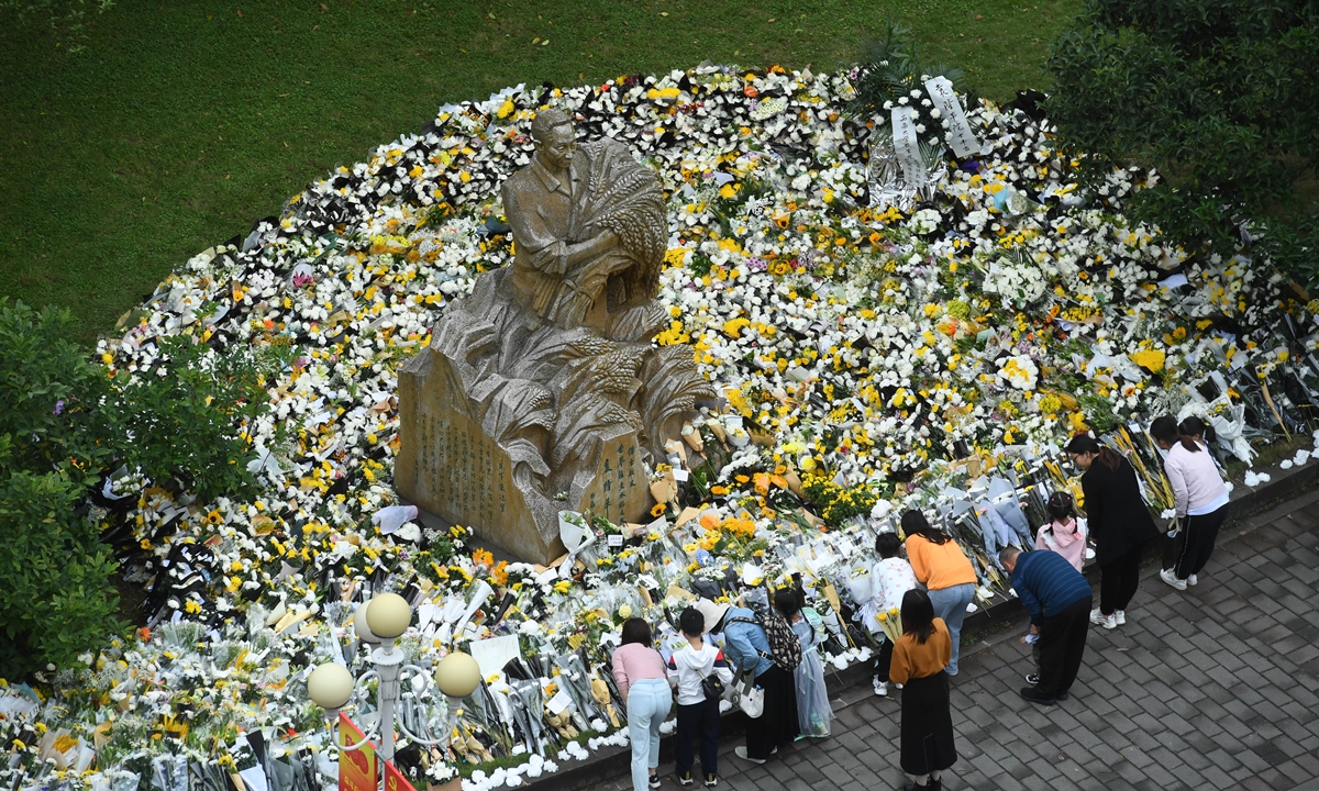 Students present flowers in front of a statue of Yuan Longping at Southwest University in southwest China's Chongqing on Sunday. Yuan, renowned for developing the first hybrid rice strain that relieved countless people of hunger, died of organ failure at 91 on Saturday. Yuan graduated from the Southwest Agricultural College (now the Southwest University) in 1953. Photo: cnsphoto