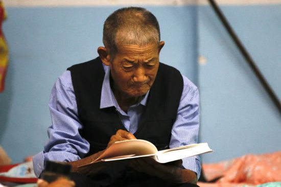 眼里有光81岁老人洪灾中坚持读书